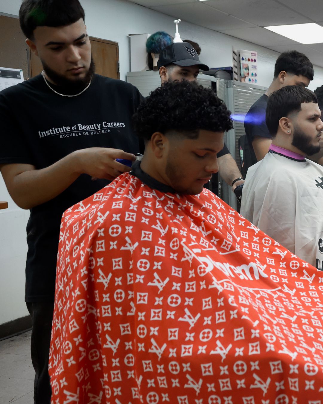 Estudiante de barbería cortando cabello en el taller