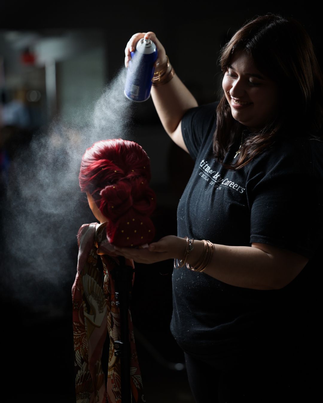 Estudiante de cosmetología fijando un color rojo vibrante