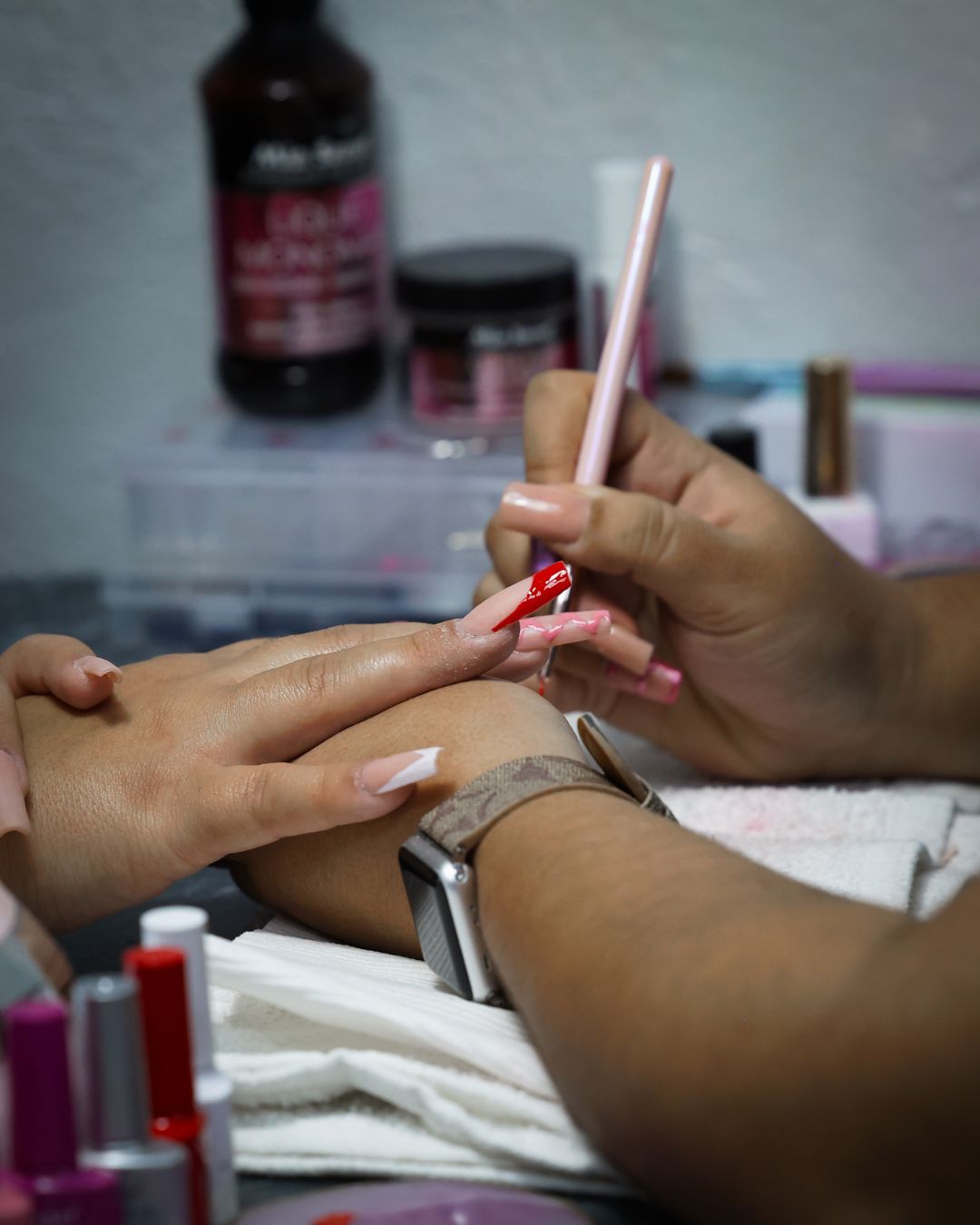Estudiante aplicando uñas acrílicas